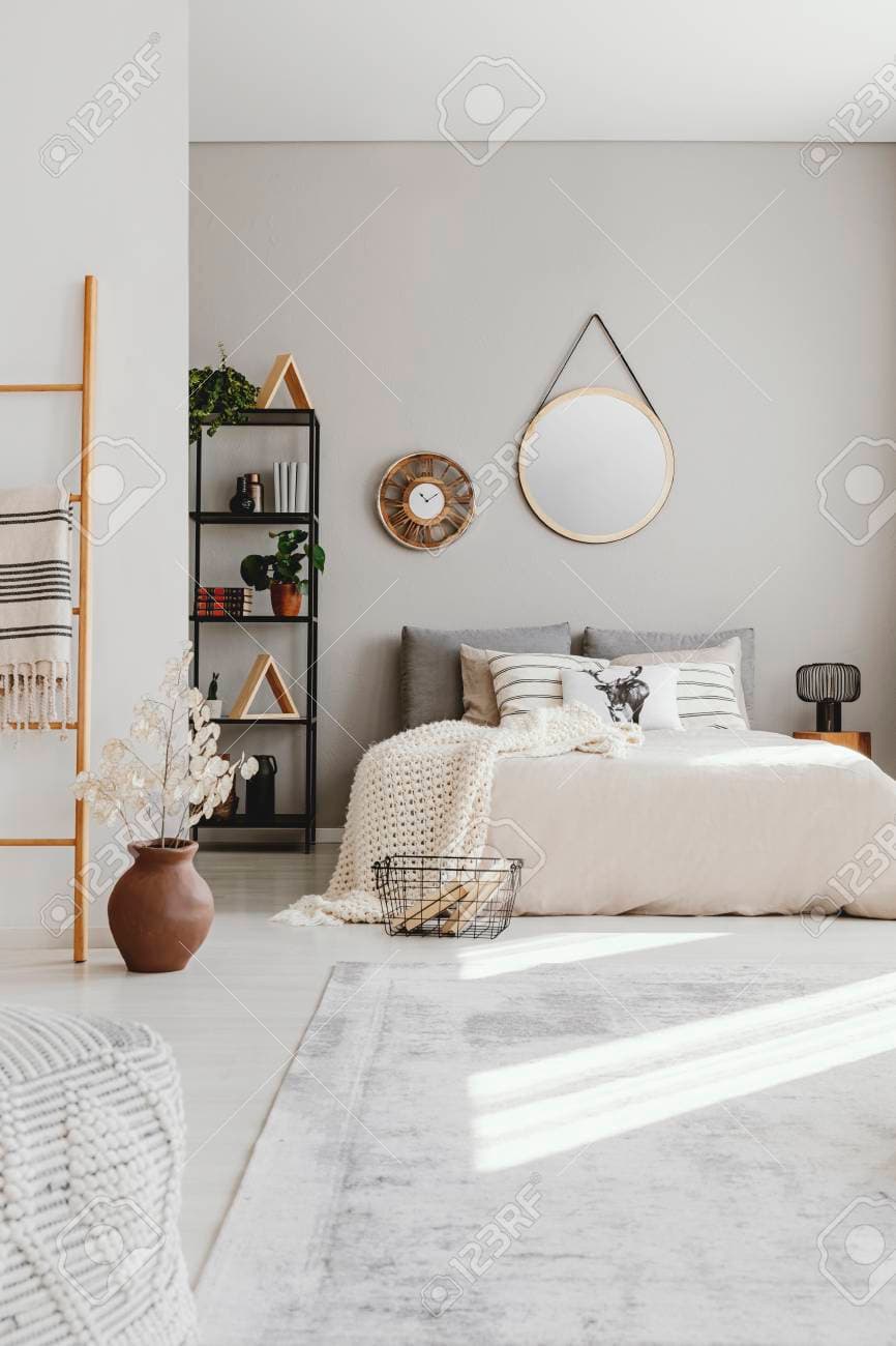110464630-vertical-view-of-elegant-ethno-bedroom-with-king-size-bed-stylish-carpet-and-round-mirror-on-the.jpg